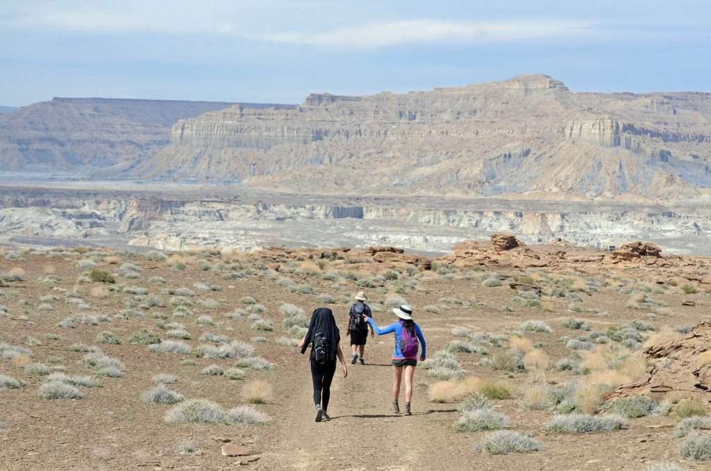 group of three walking through desert