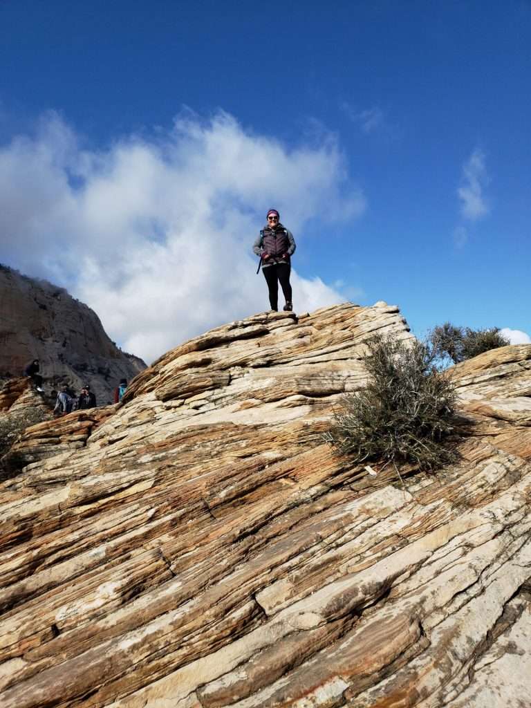 woman standing high above of rock formation