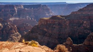 A breathtaking view of the Grand Canyon, showcasing layered red rock formations and deep valleys under soft sunlight.