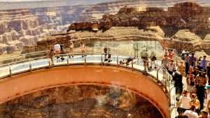 Visitors stand on the Grand Canyon Skywalk, marveling at stunning rock formations and the expansive canyon view.
